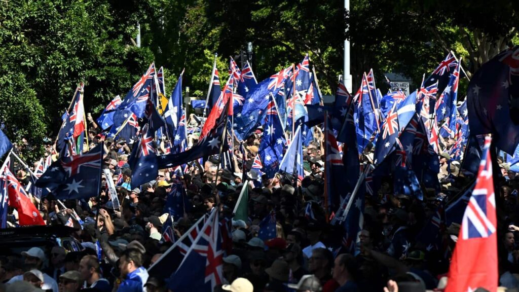 The Paradox Behind Calls To End Mass Migration In Australia 1 A large crowd, many of whom are waving Australian flags.