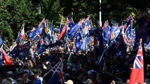 Home 36 A large crowd, many of whom are waving Australian flags.